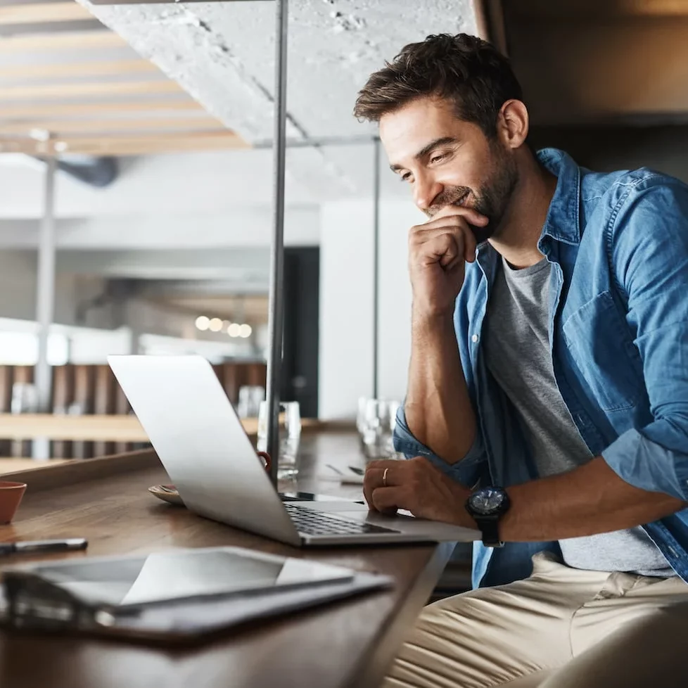 man smiling at laptop