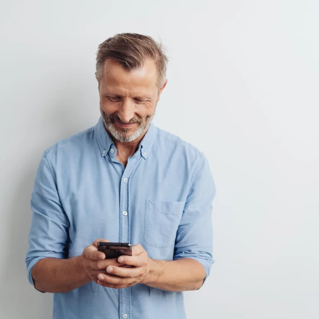 man_looking_at_phone man looking down at his phone smiling